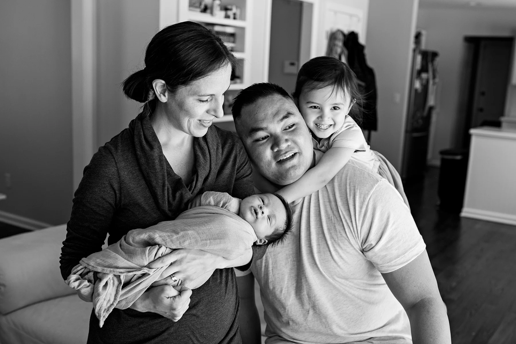 daughter hugging dad around neck at lifestyle newborn photography in middletown connecticut