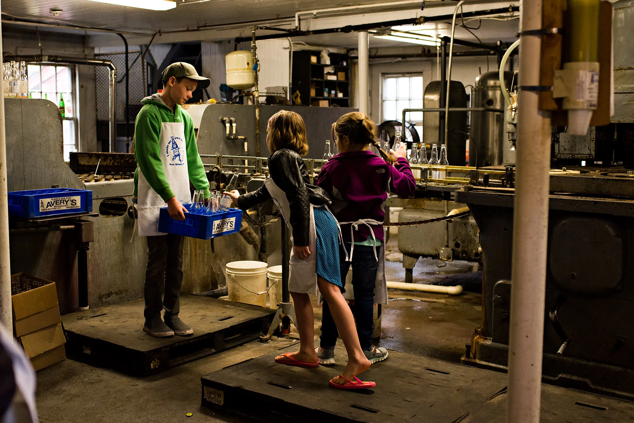 children filling carton with clean soda bottles averys soda connecticut documentary photographer 
