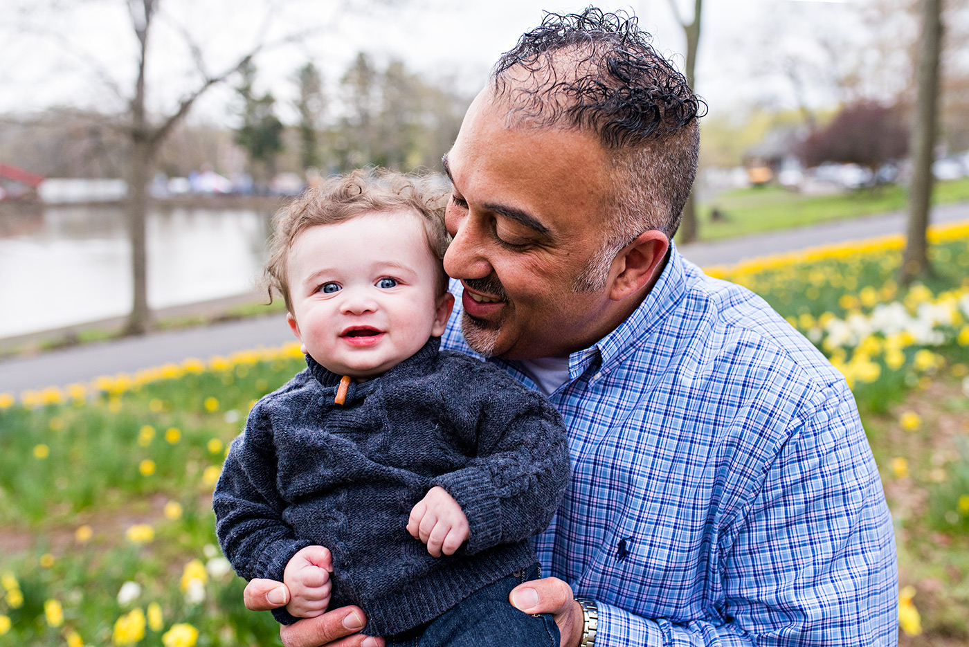 father smiling and infant son in field of daffodils meriden connecitcut infant photography