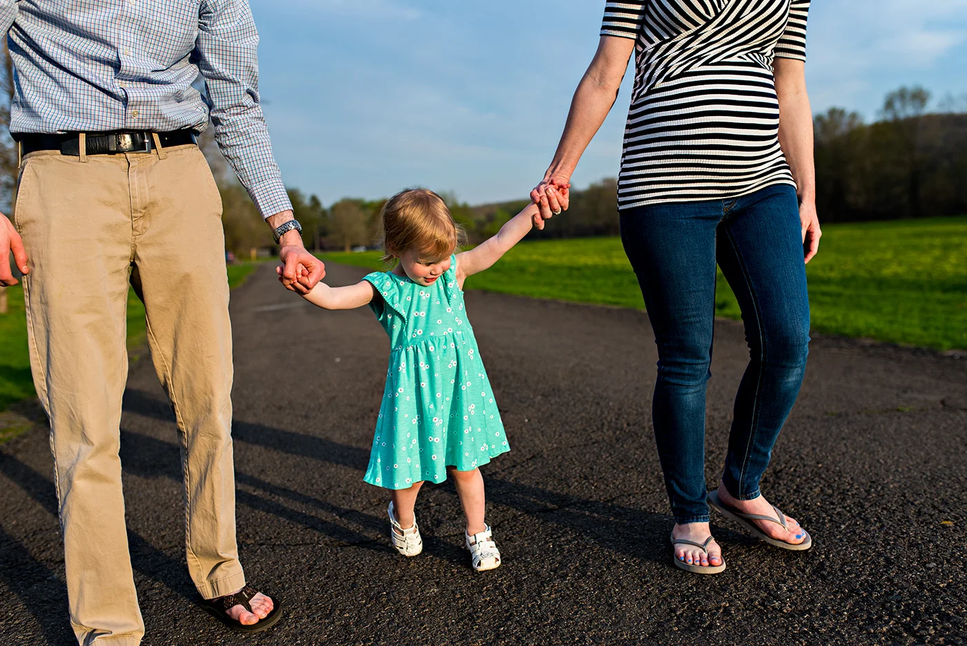 daughter holding mom and dads hand walking in field at haddam meadows in haddam connecticut lifestyle maternity photography