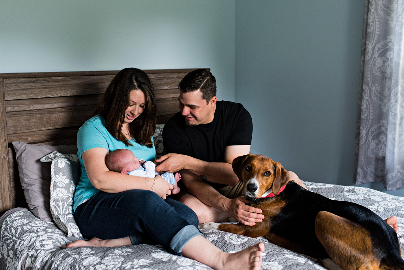 mom and dad with newborn and dog on bed southington ct newborn photography