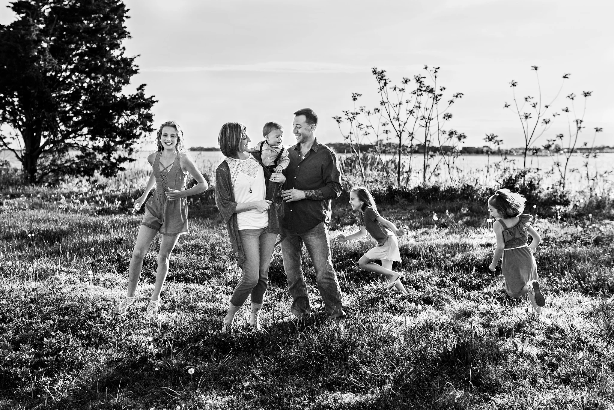 children running around parents in field lifestyle family photography ct