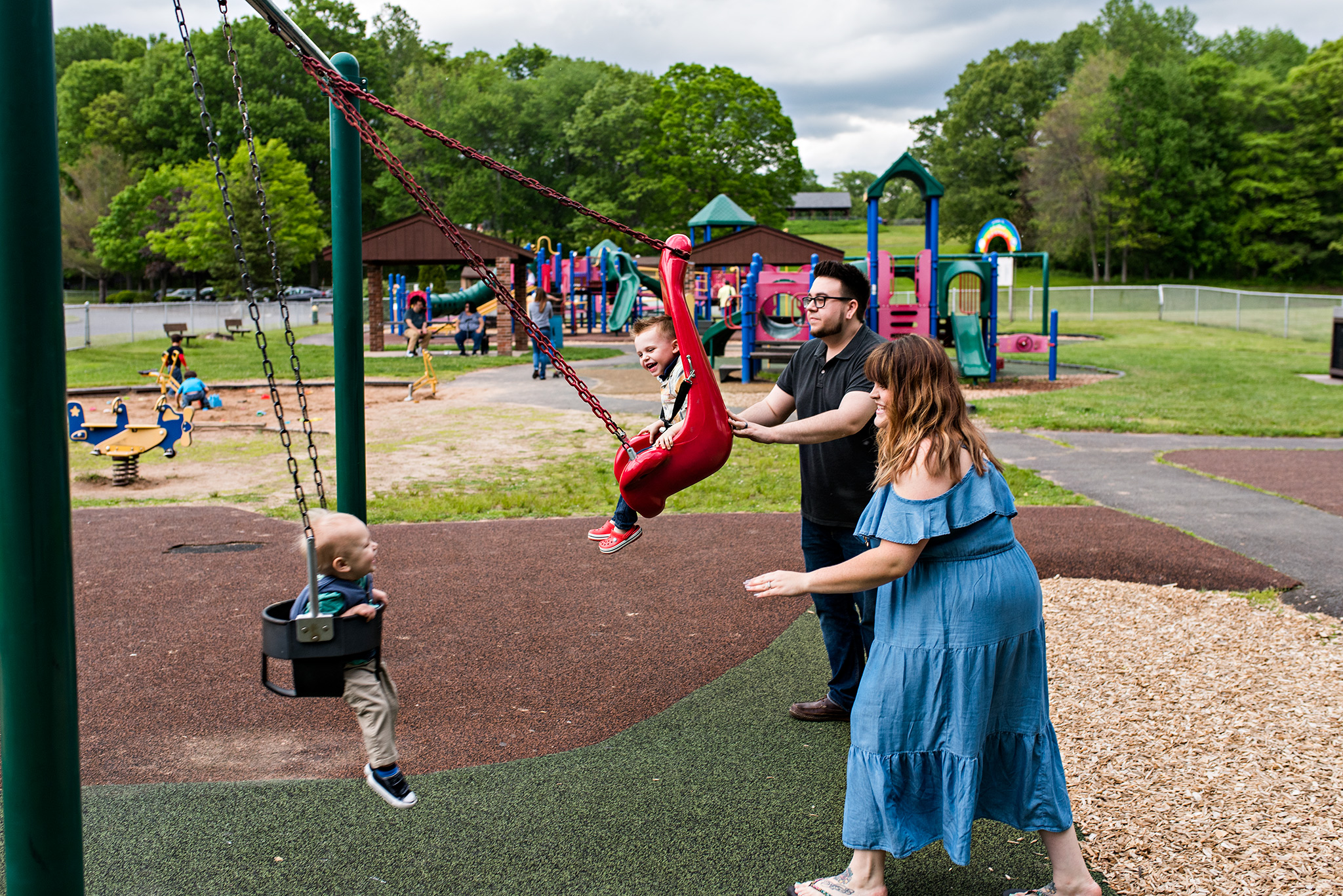 parents pushing children on swings at the park plainville ct family photography 