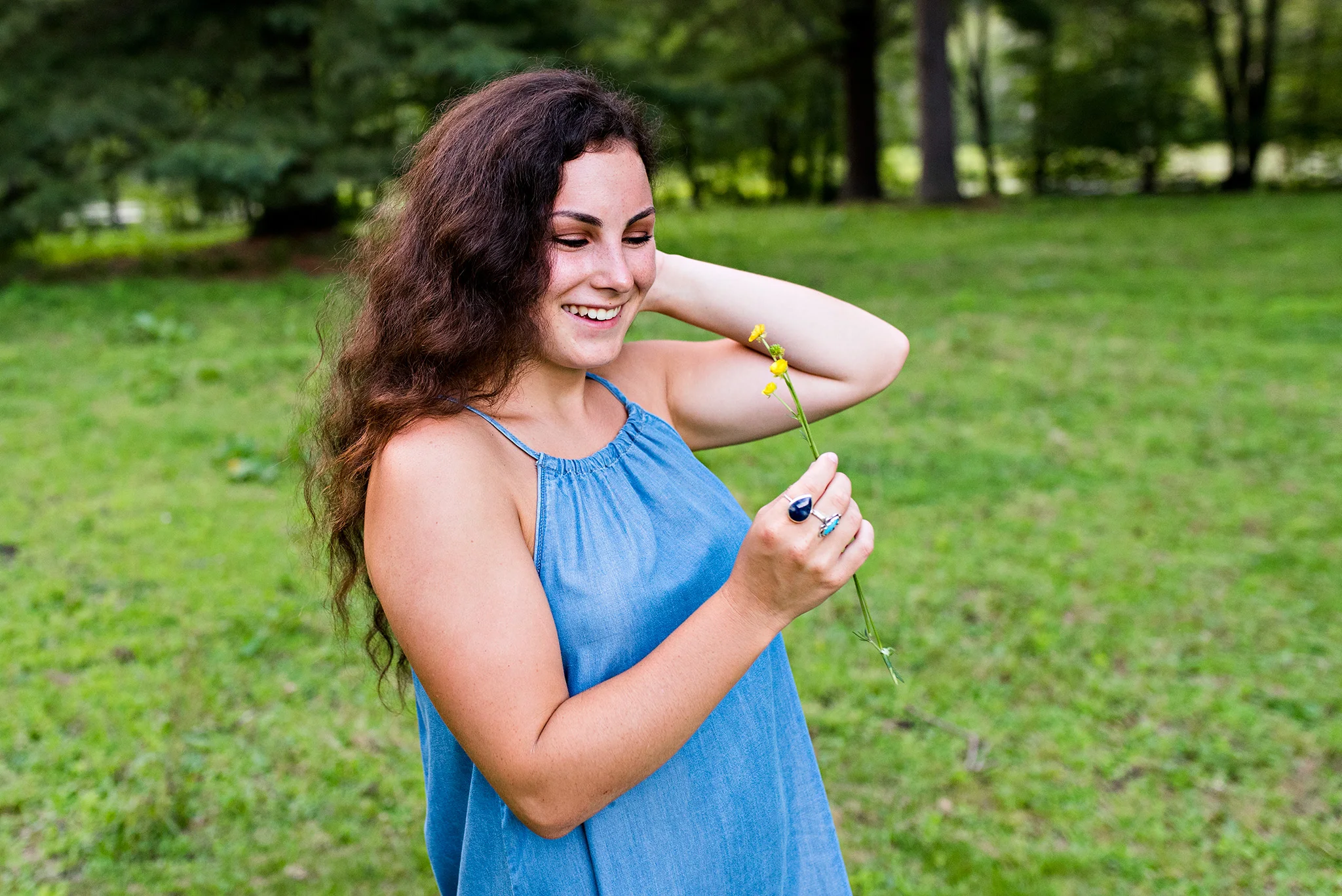 ct high school senior photographer picking flowers in a field 