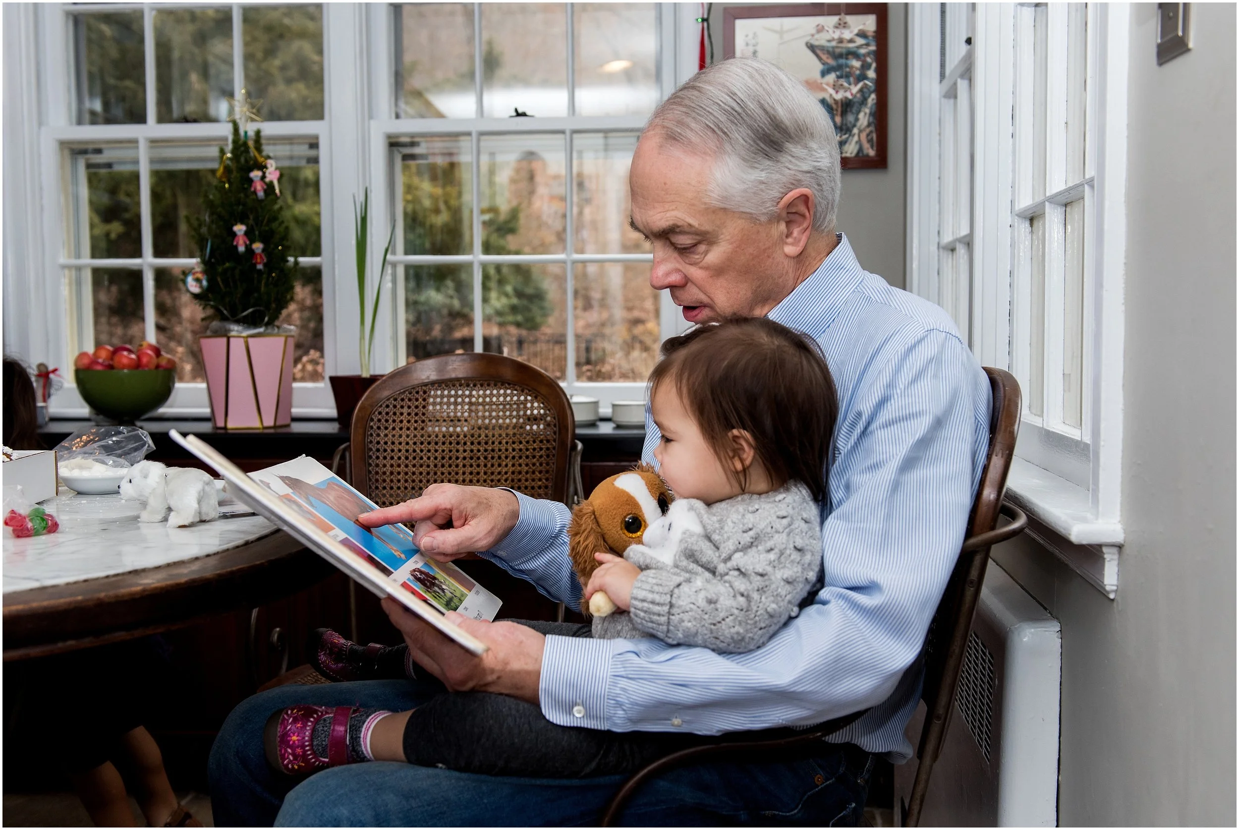 grandpa reading book to granddaughter during ct extended family photography