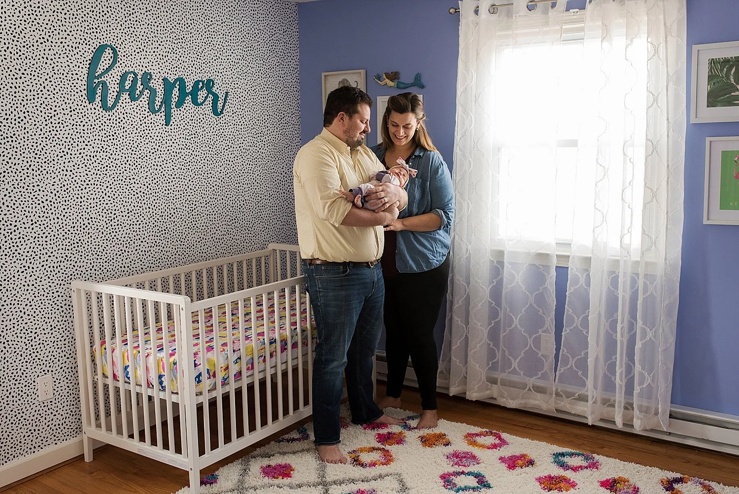 Connecticut Newborn Photographer, Rebecca Lynne photographing a mom and dad holding their baby in her nursery