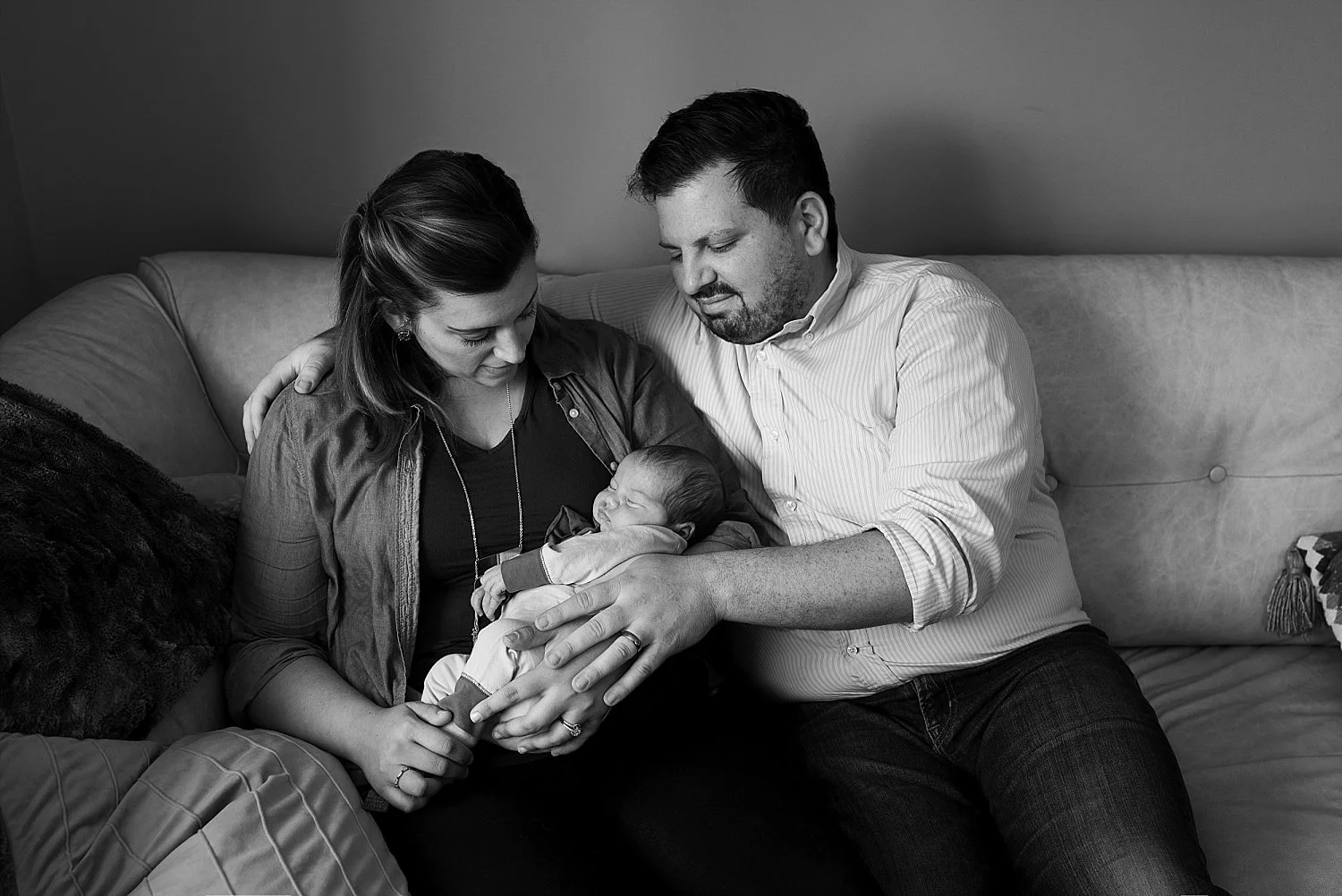 Black and white images of mom and dad cradling their baby during their ct newborn photography