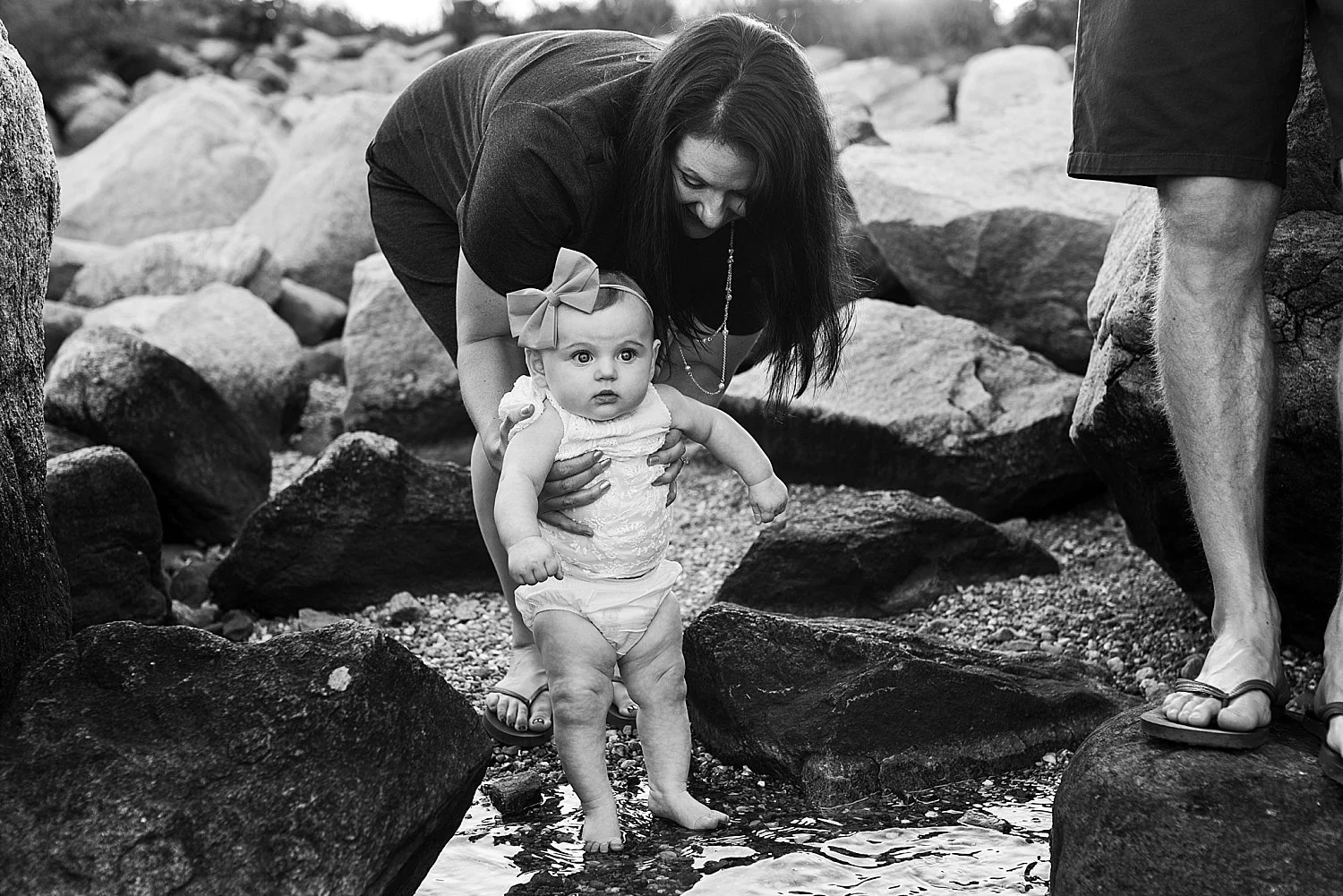 Baby girl tipping her feet in the ocean for the first time at her CT family photo session