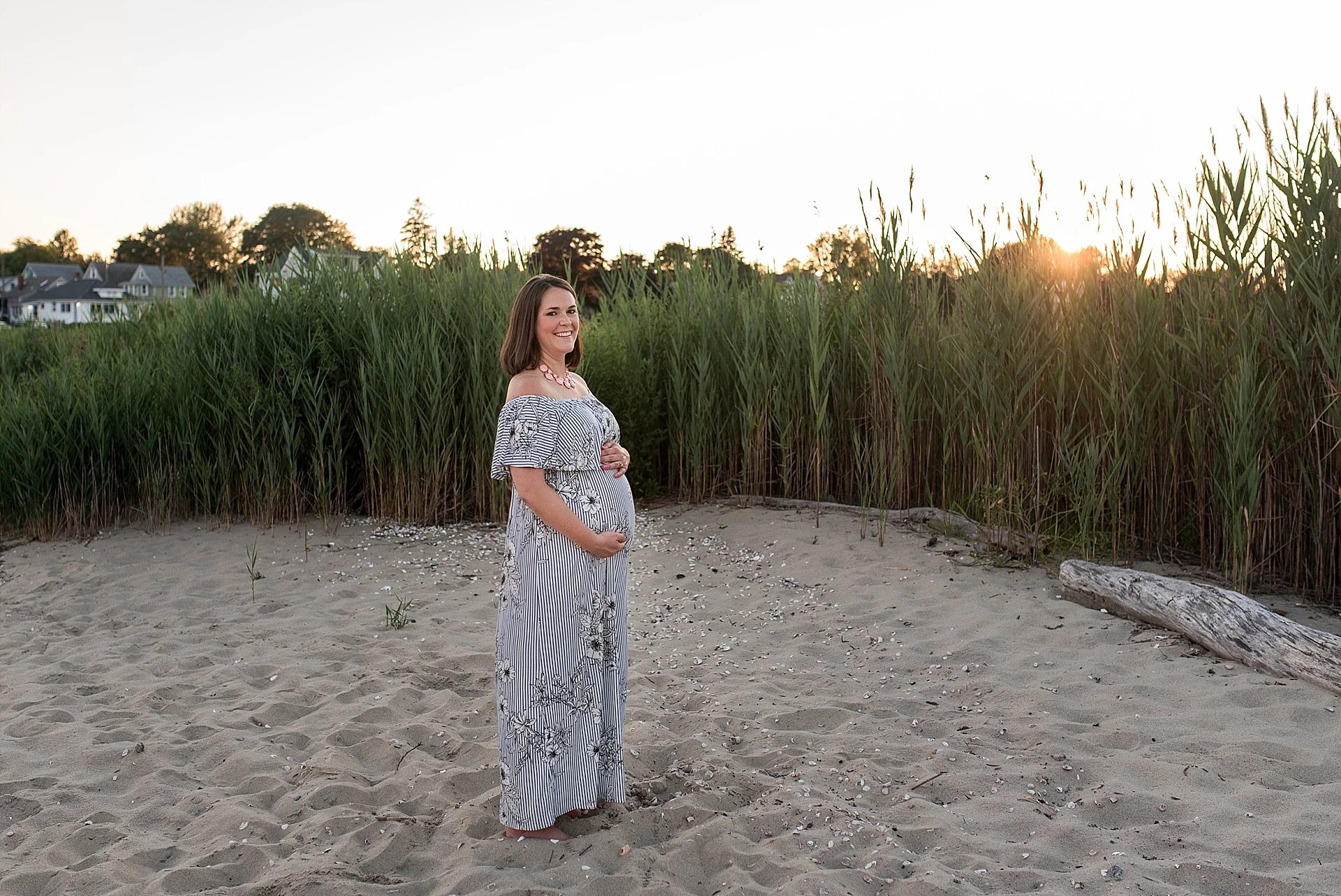 Expecting mom in a blue and white maxi dress at sunset during her CT maternity photo session