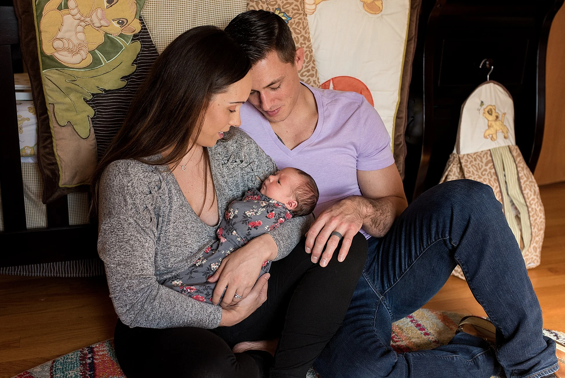 New parents cuddling their newborn daughter in her nursery. CT newborn photographer