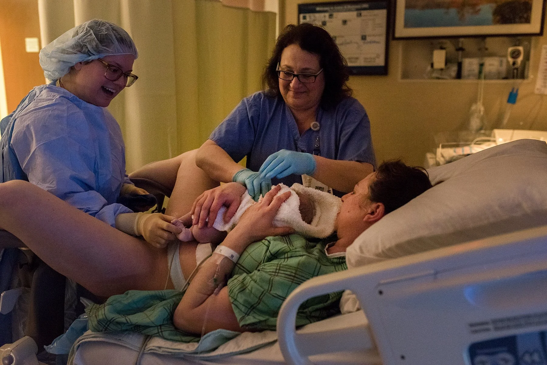 Birth photography CT. Mother holding newborn daughter for the first time after delivery.