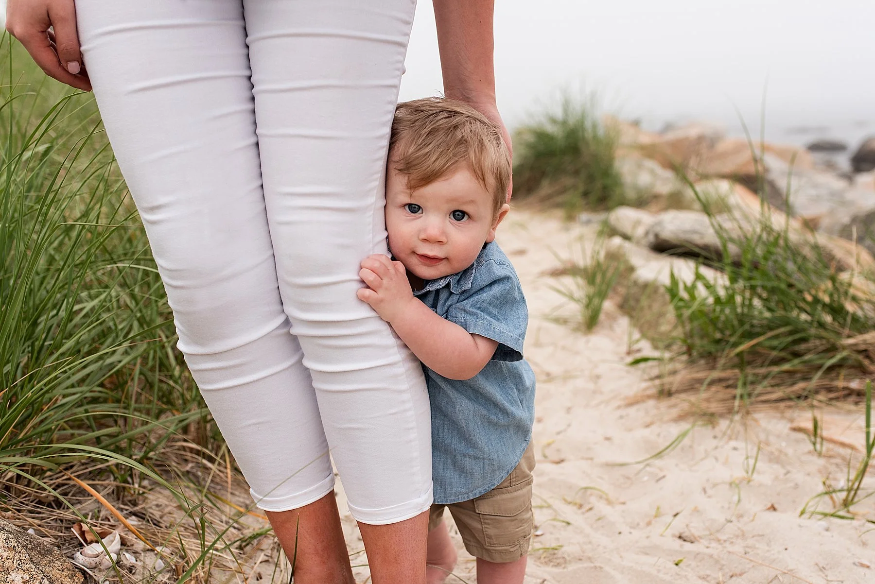 toddler hugging Mom’s legs during CT family photography