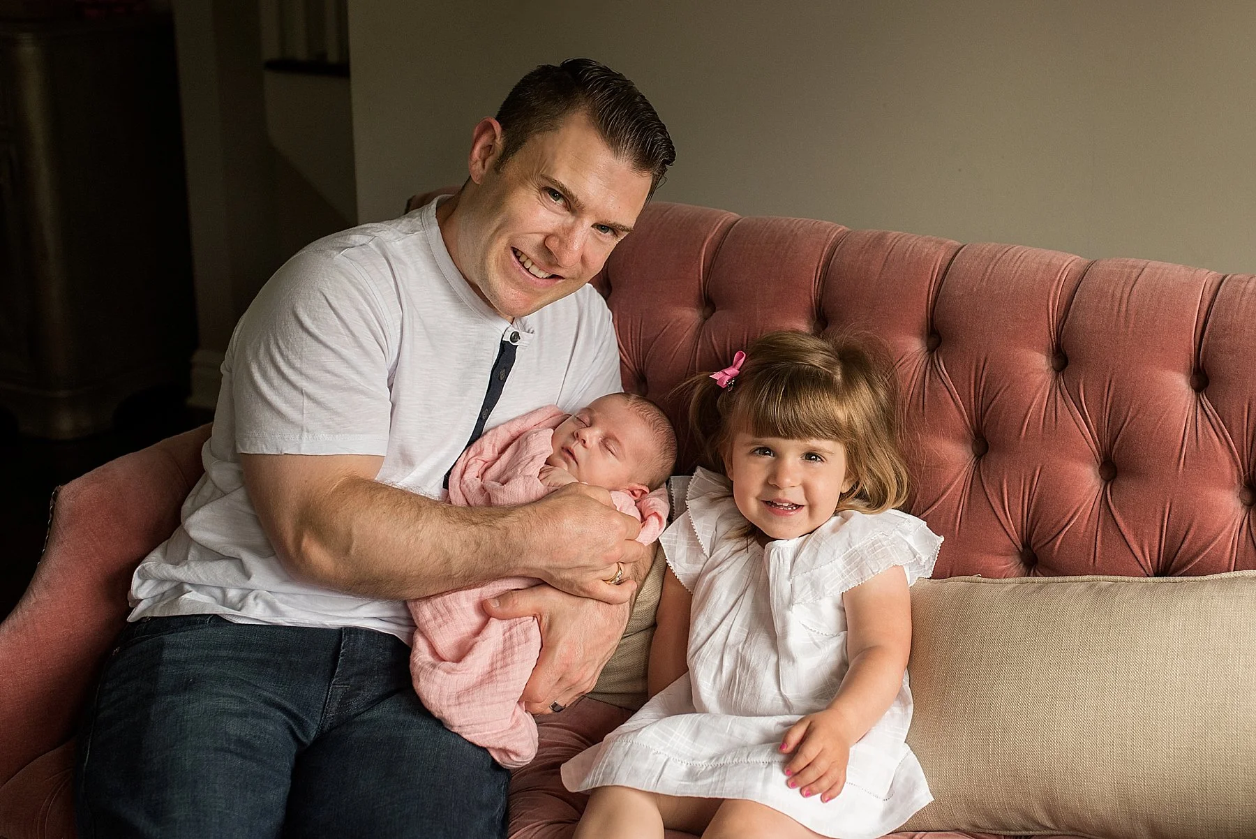 dad with his daughter’s in living room during CT baby photography