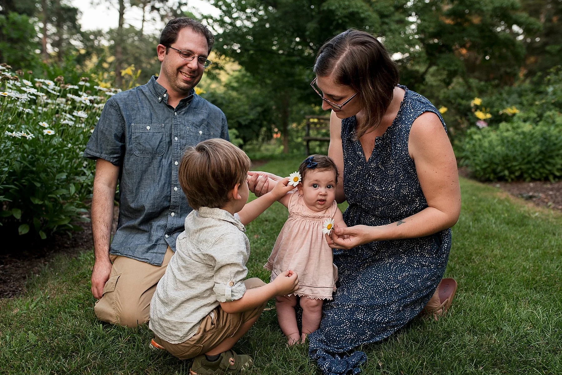 mom and dad with children sitting in the grass at connecticut park