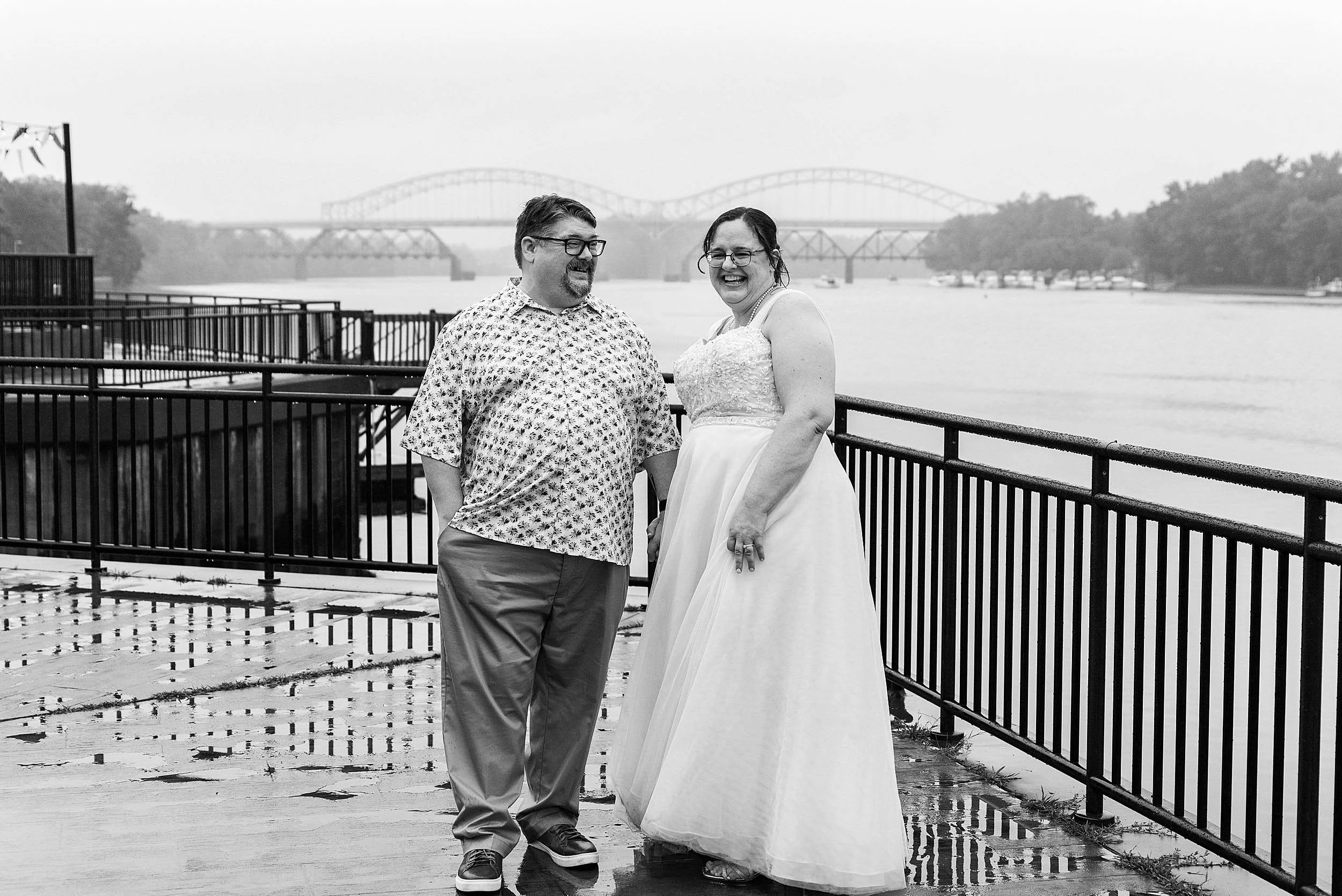 bride and groom laughing together on boardwalk along Connecticut River in Middletown