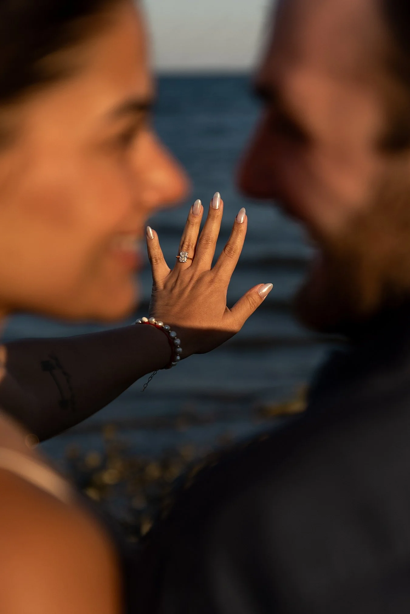 The couple laughing together with the Charles Island sandbar in the background.