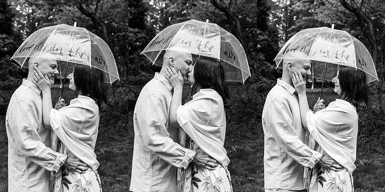 bride and groom kiss under umbrella during rainy backyard wedding in CT