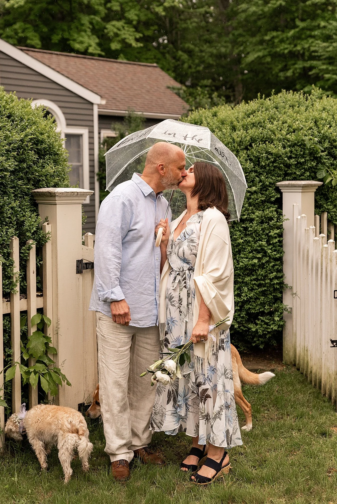 bride and groom in front of fence in their backyard elopement CT