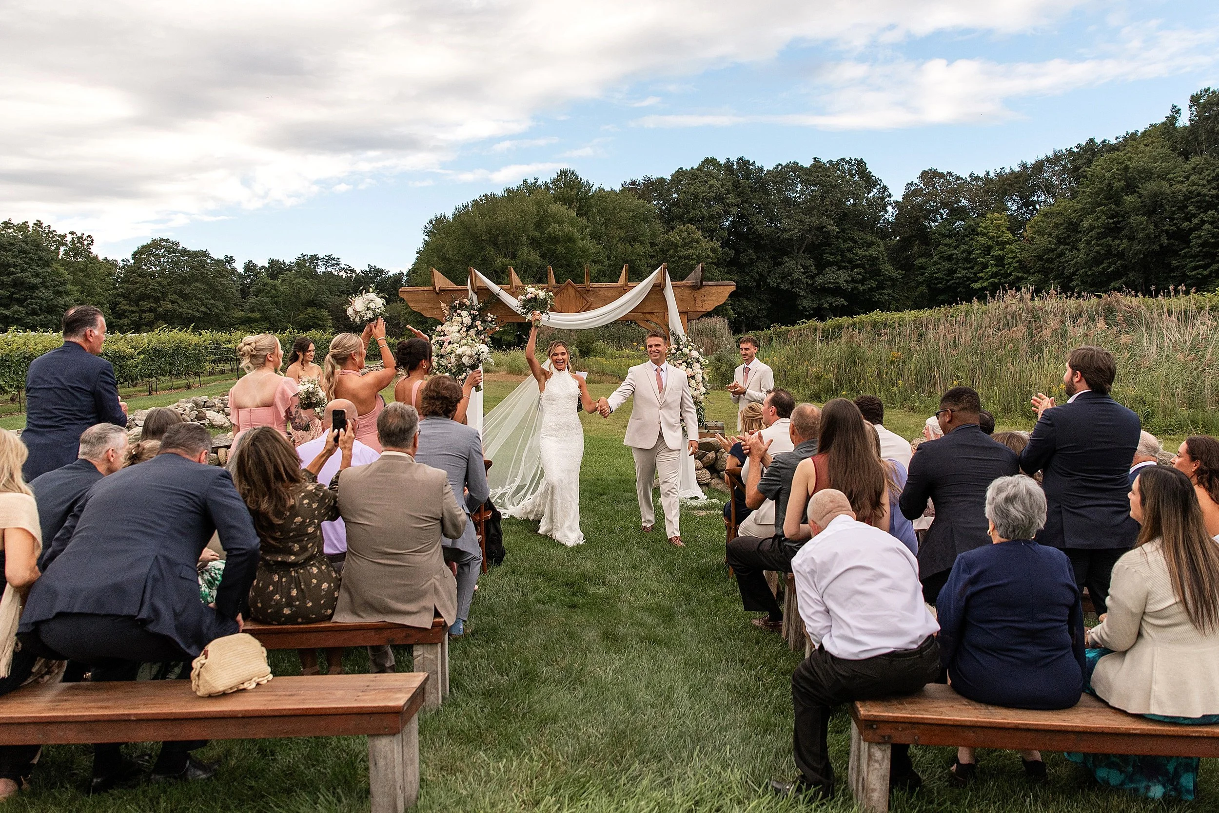 bride and groom hand in hand celebrating after their first kiss