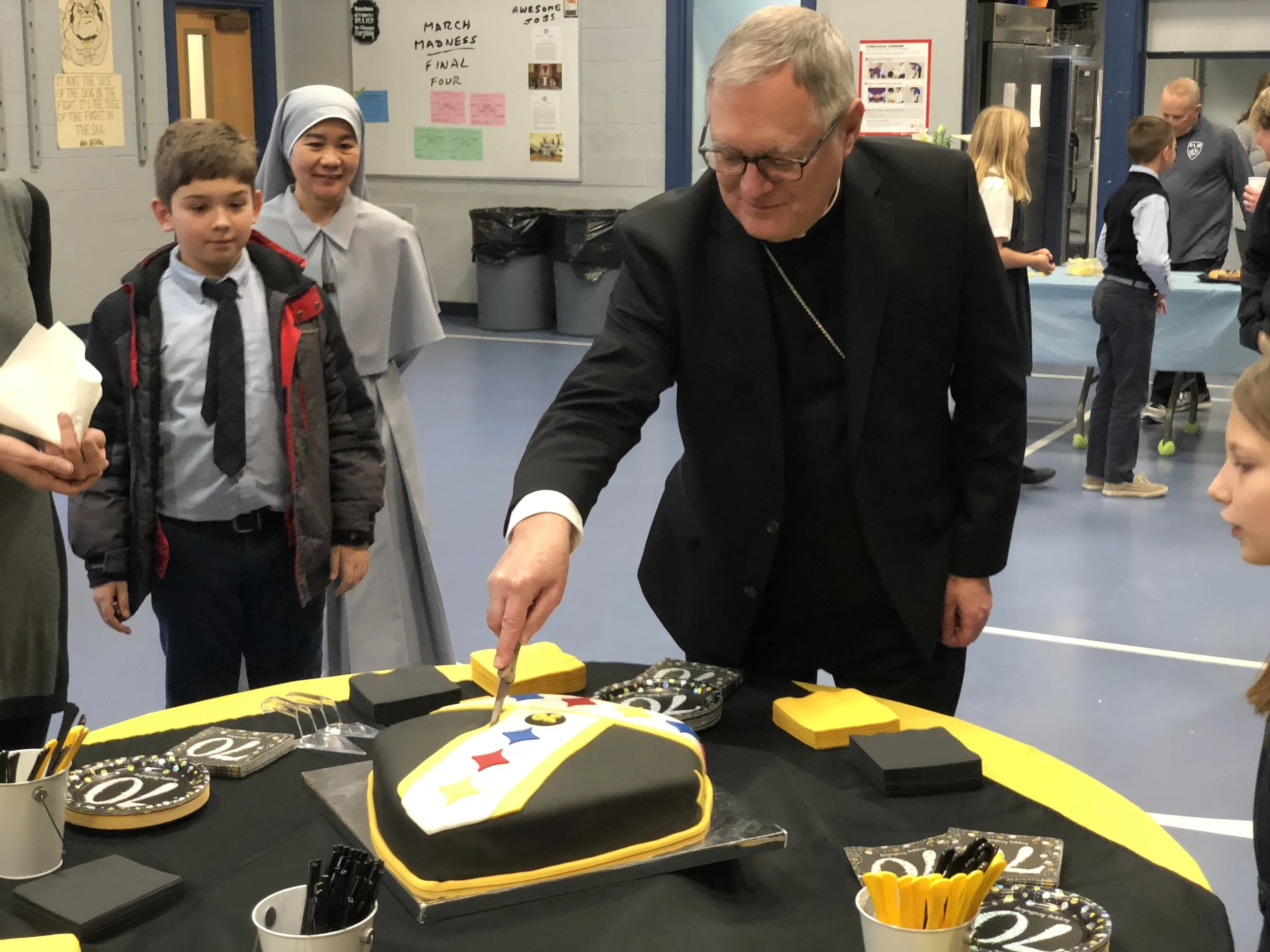 Bishop Tobin happily cuts his birthday cake!
