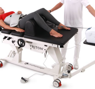 Medical professional adjusting a patient on a Triton therapy table.