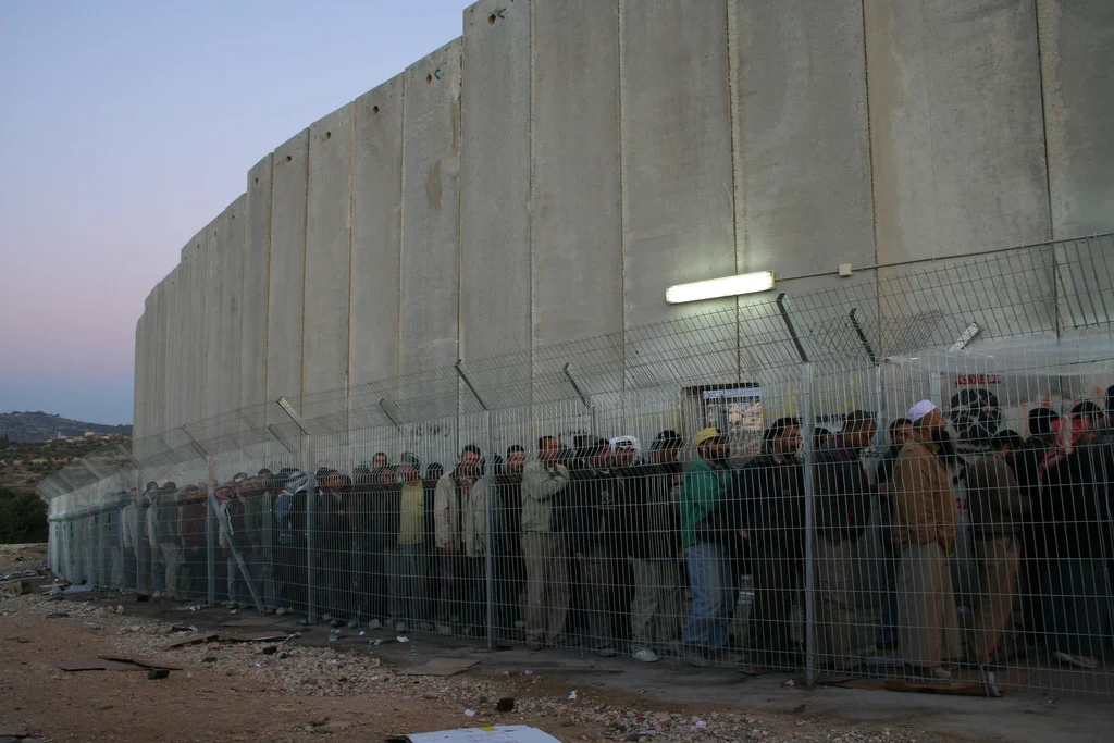 Men and women from all over the Southern West Bank stand in line for hours each morning on their way to work outside of Bethlehem.