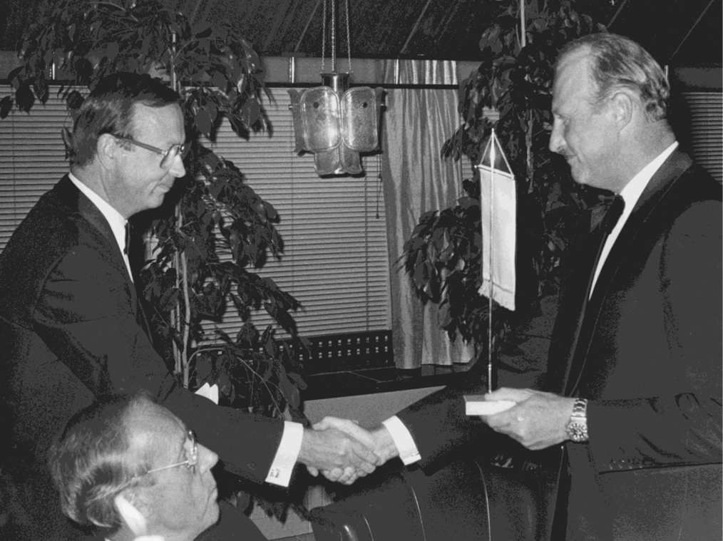 Ordf. Stig Simelius overrekker foreningens standard nr. 1 til HKH Kronprins Harald på festmiddagen på Palace 5.9.1985. Minister Tankmar Horn bevitner seremonien.