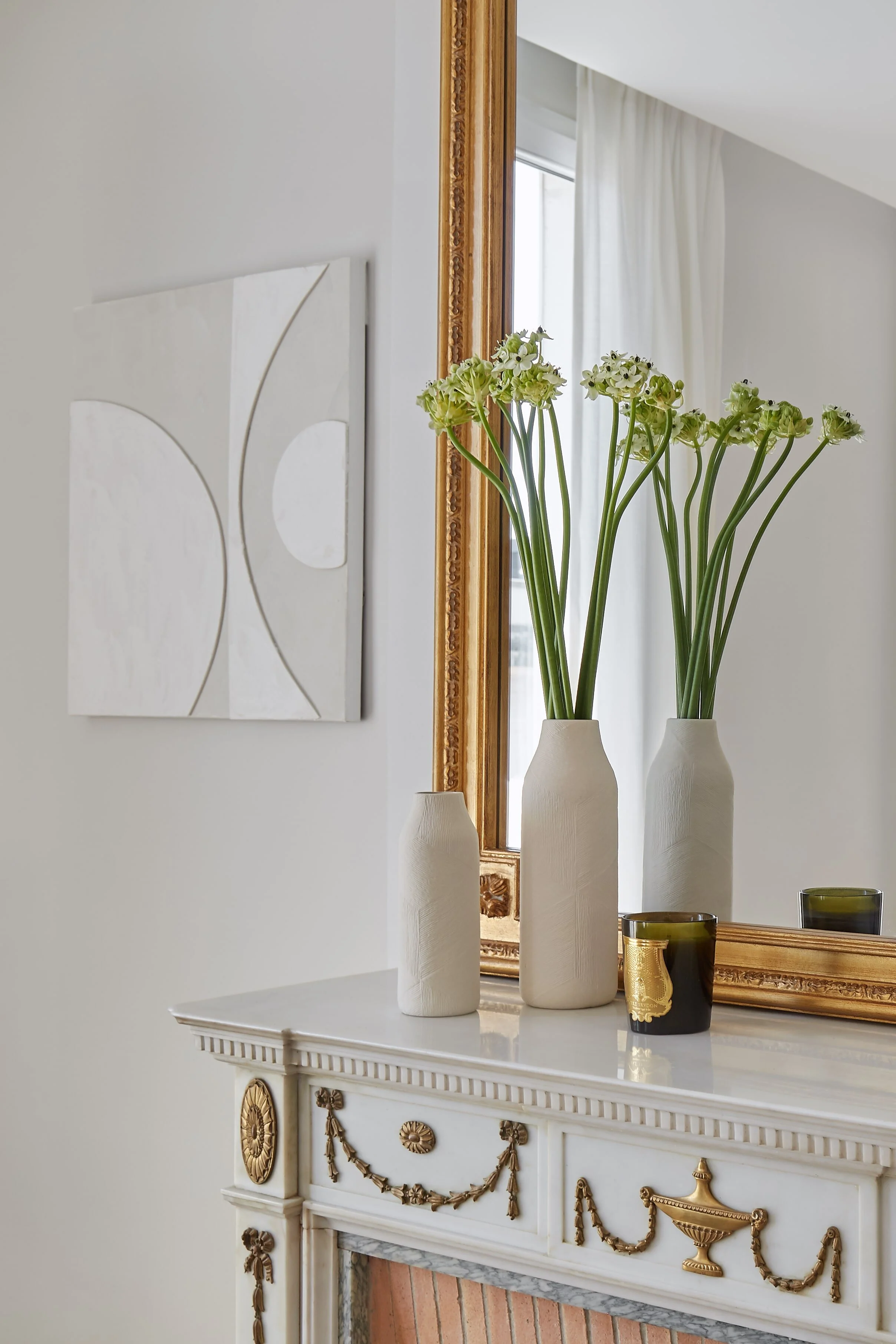  Minimalist white vases with flowers on a classic fireplace mantel 