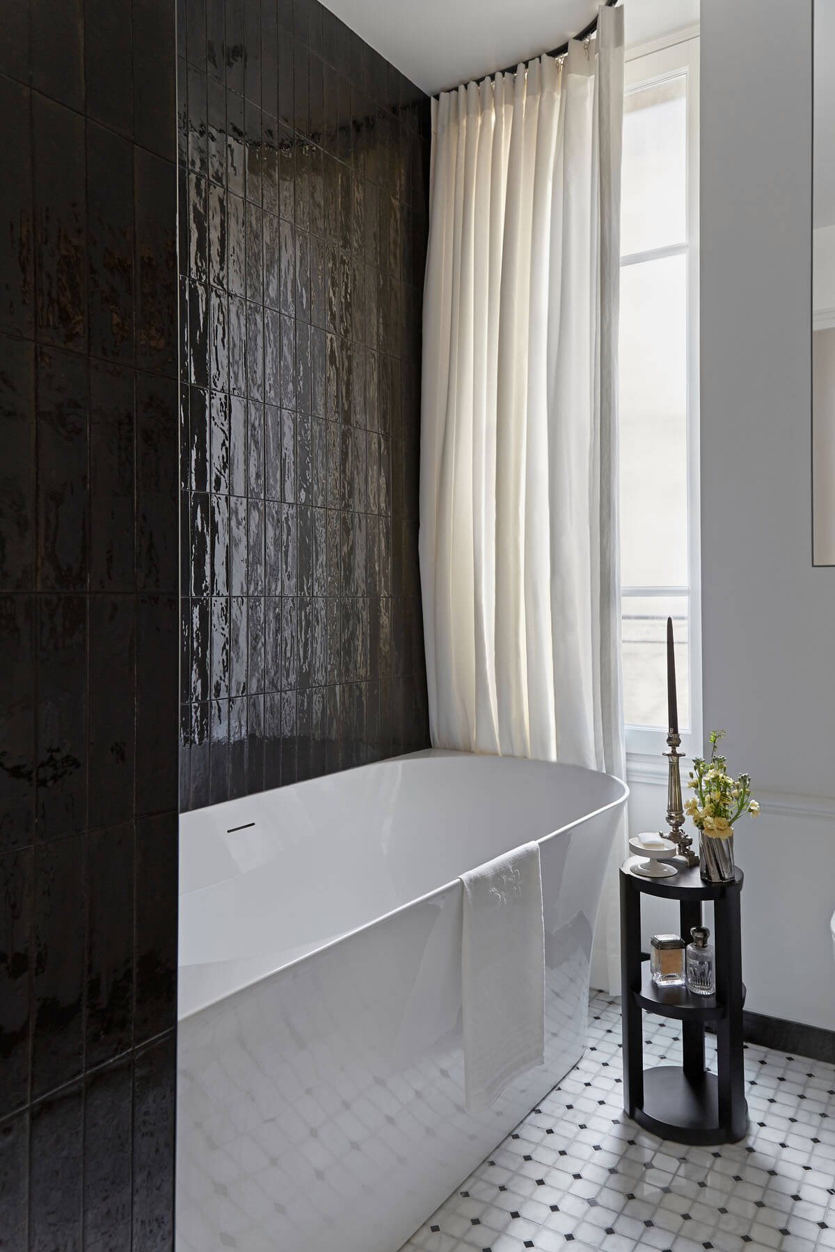  Although there is mostly modern elements in this bathroom there is an old-world charm that I adore. The marble black and white flooring, black tiles, and unlacquered brass fixtures you will see in the next post are a classic mix, but the vertically 
