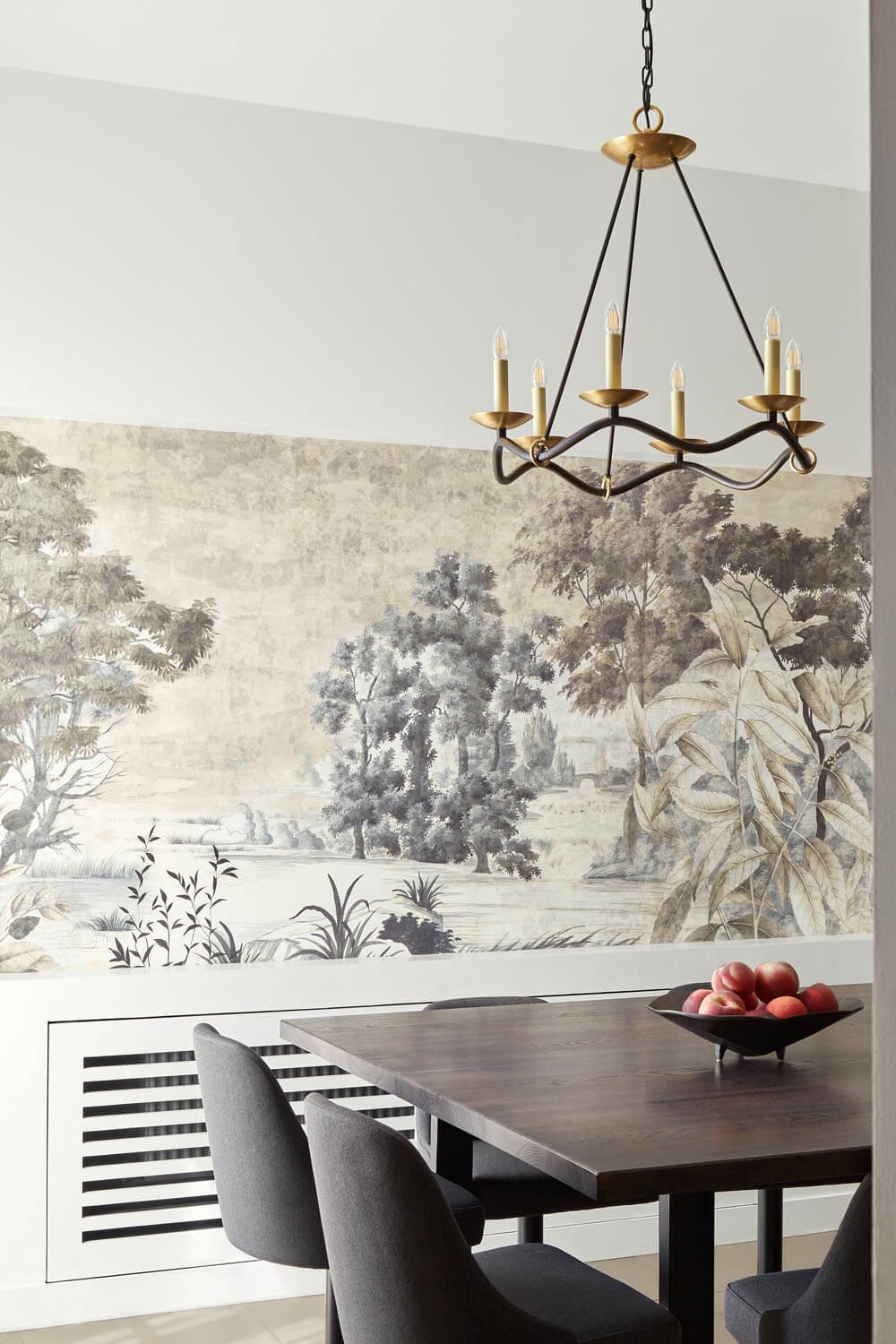  Dining room with wooden table and black chairs, and decorative chandelier. 