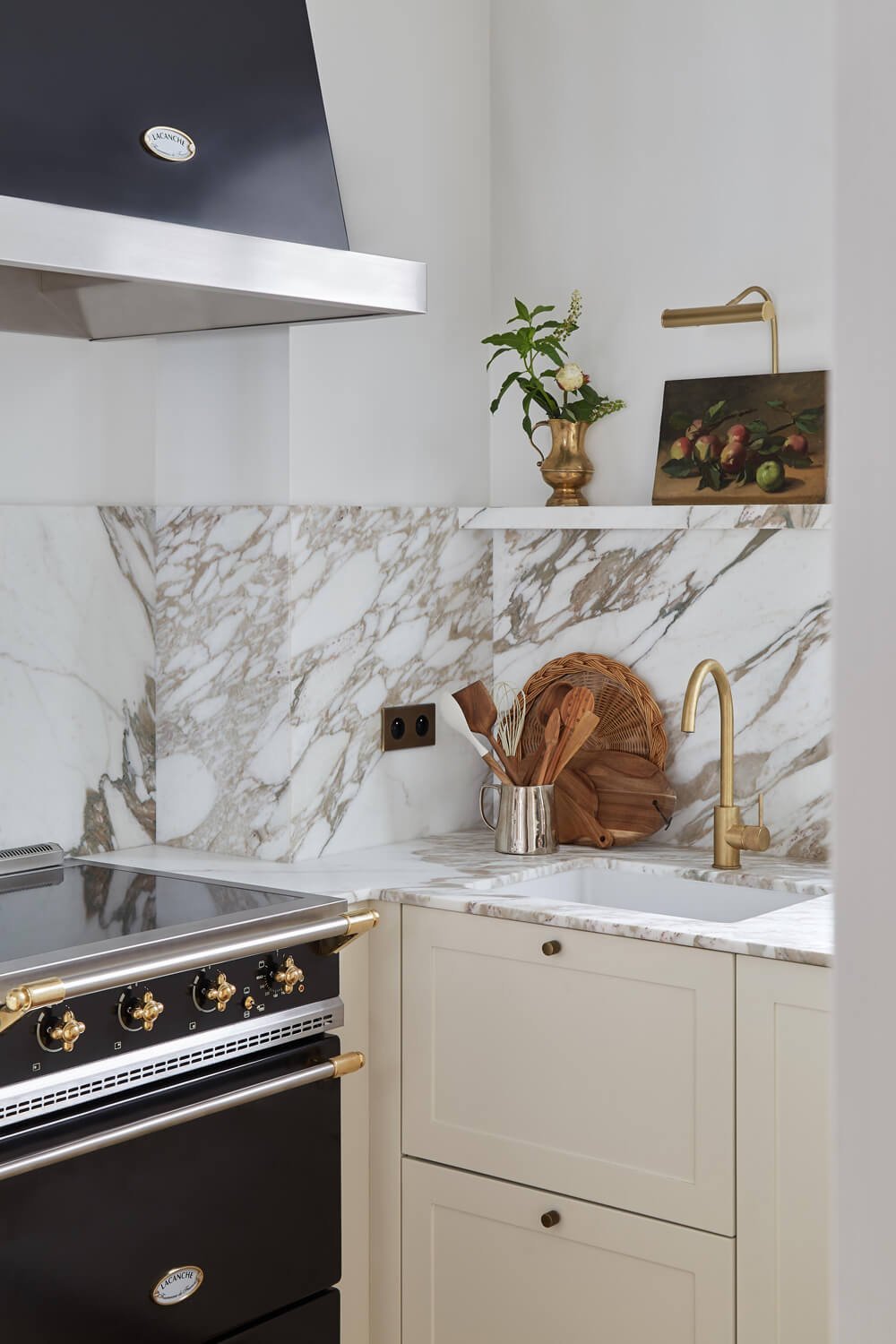  A very chic corner of the functional kitchen. The marble backsplash is a perfect match to the golden fixtures in the kitchen. 