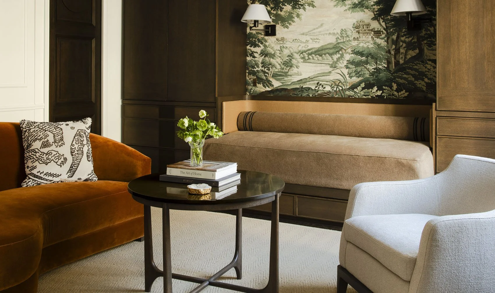 Parisian living room detail with rust velvet sofa, white armchair, oval side table and toile de jouy landscape artwork
