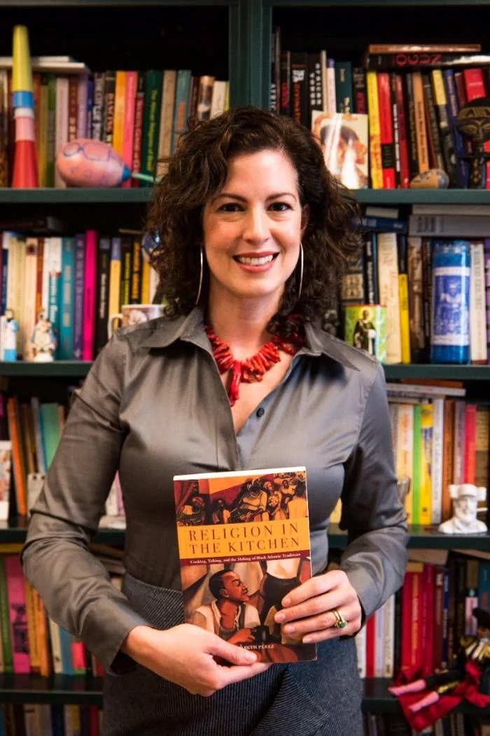 Elizabeth Pérez with her first book, Religion in the Kitchen: Cooking, Talking, and the Making of Black Atlantic Traditions , in her office at UCSB.