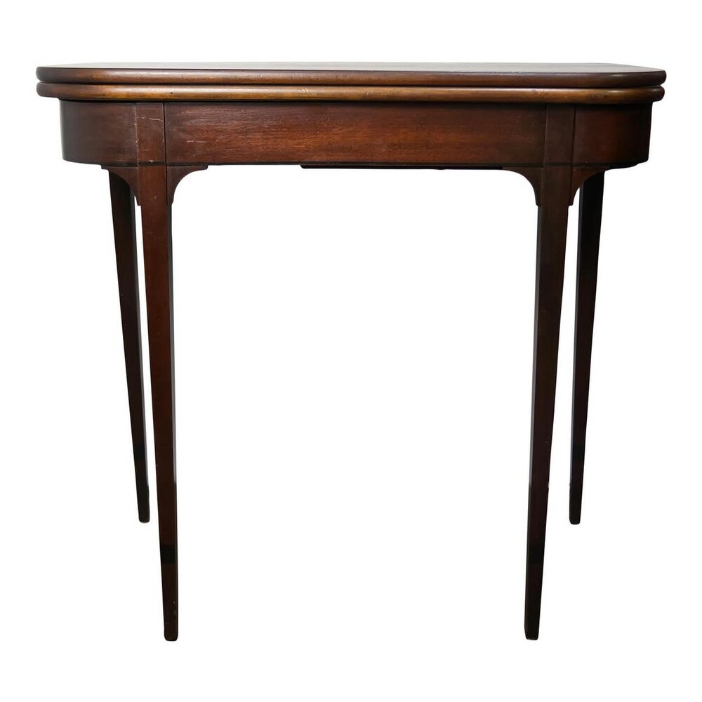 A 1940s-1950s mahogany game table with a twist and fold out top manufactured by Imperial Furniture Company from Grand Rapids, MI. The apron features a small storage space for playing cards or coasters that can be accessed by twisting the top. When th