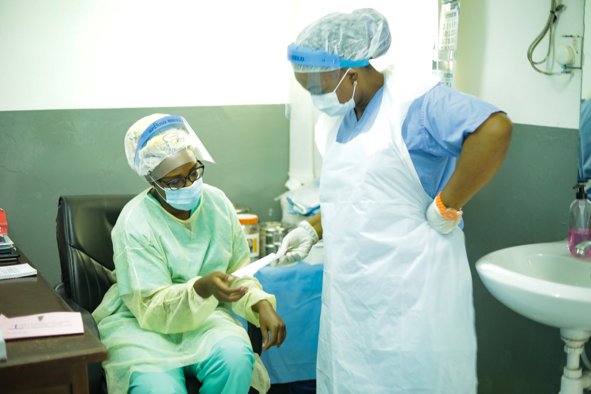 A doctor and a nurse discuss patient care at a clinic in Freetown