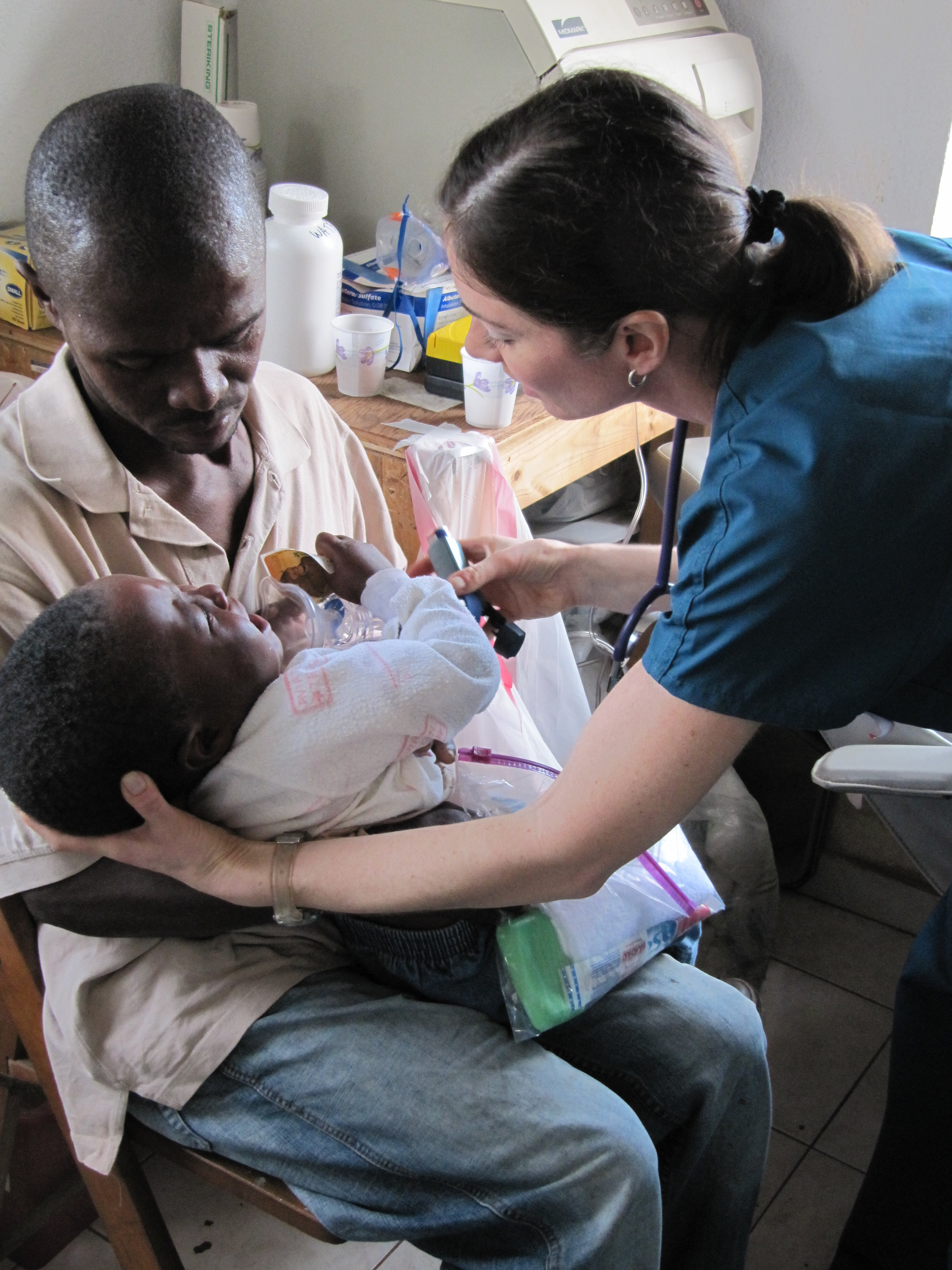 Medical professional, Dawn Ribnek works with a Haitian family in the MTM clinic in Gramothe, Haiti. 
