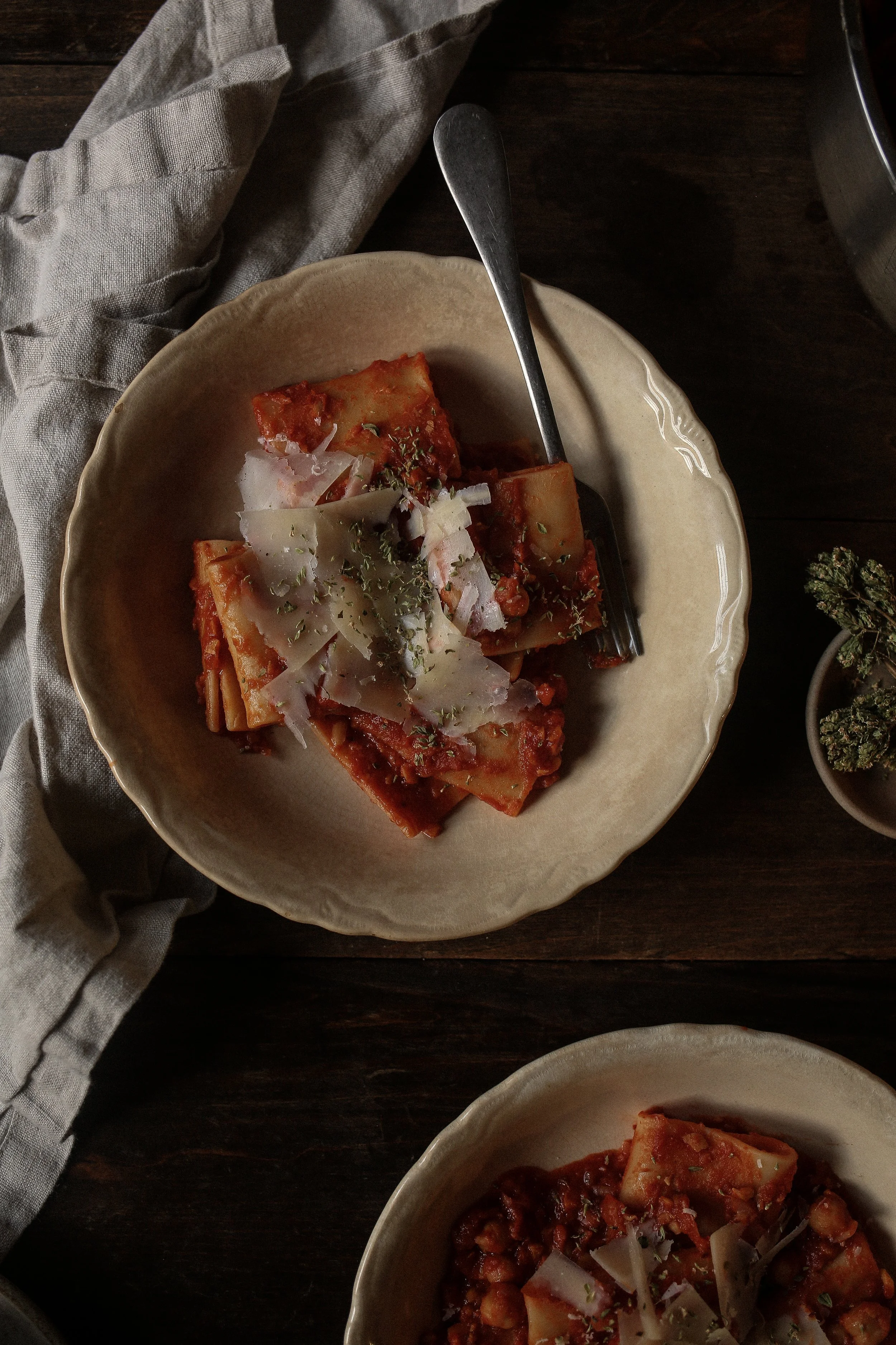 pasta e ceci served in a shallow bowl with chickpeas, paccheri pasta, rosemary, and olive oil