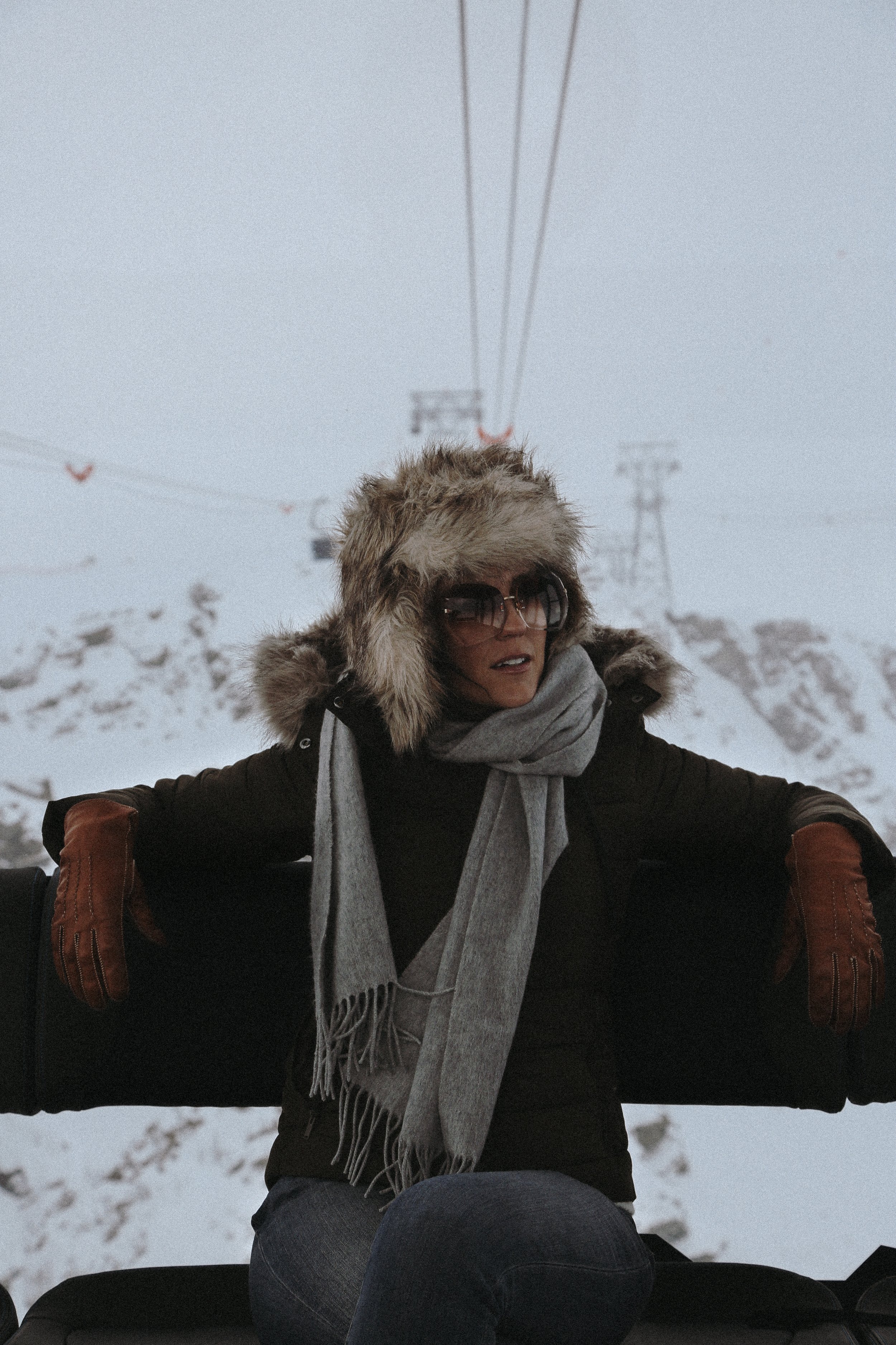 woman in alpine outfit on ski lift in Switzerland