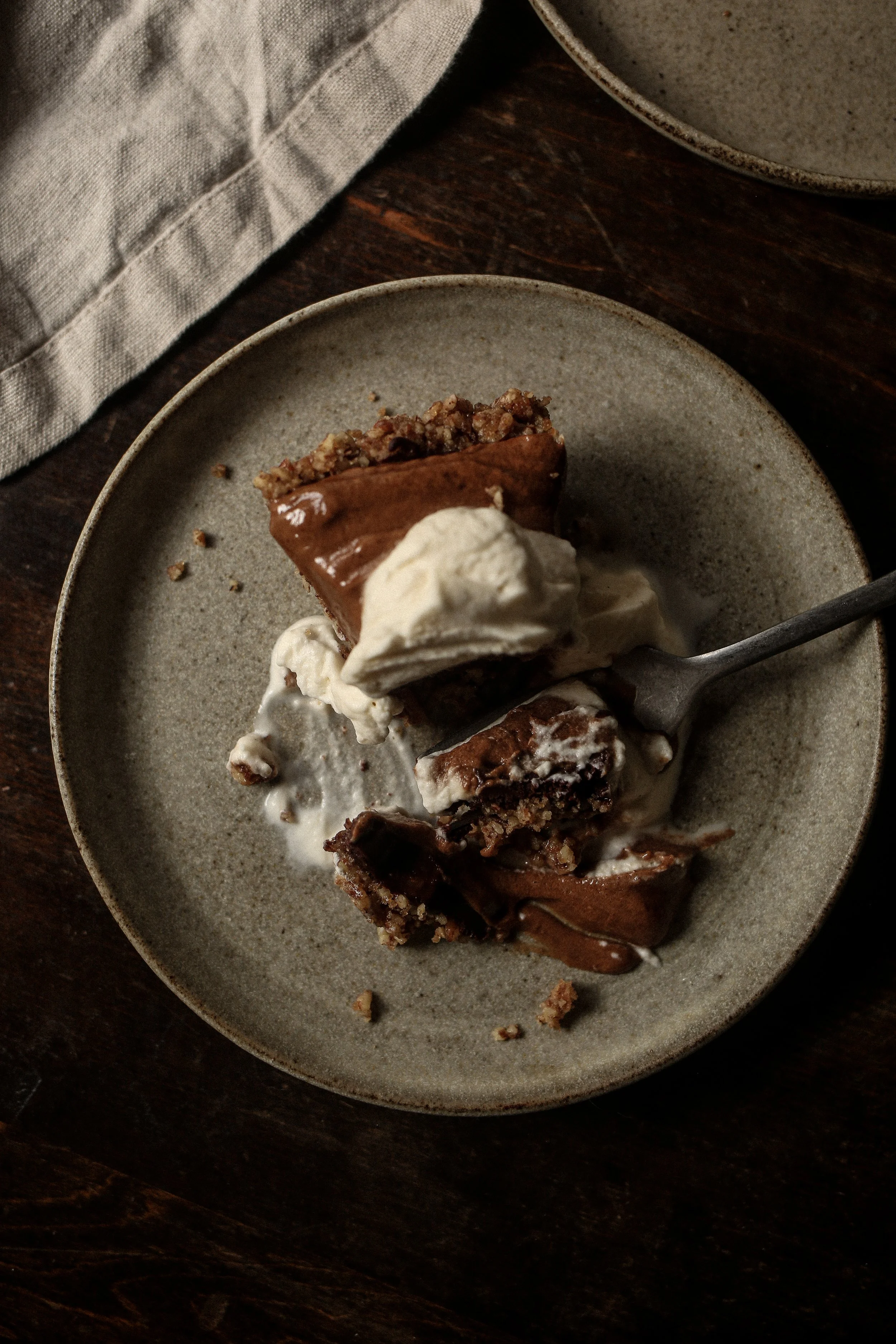 a slice of chocolate pecan torte on a plate with a bite taken out