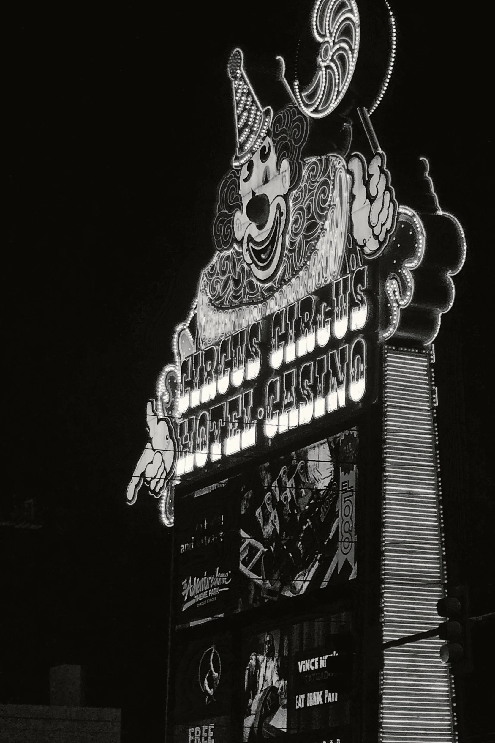 Nighttime view of illuminated sign for Circus Circus Hotel, Casino, with cartoon clown face and text.
