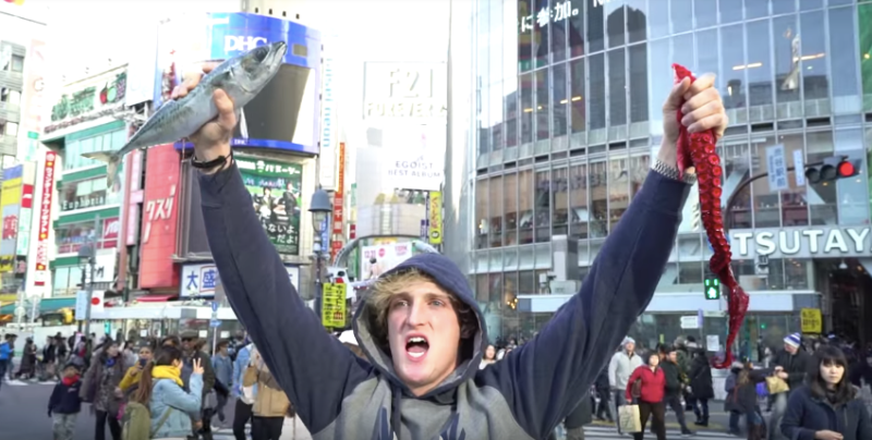 Paul holding up a live fish and octopus tentacle – bought from the world-renowned Tsukiji fish market – in the middle of a busy downtown intersection.