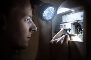 Picture of a person inspecting a fusebox
