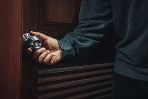 Picture of a burglar turning a doorknob