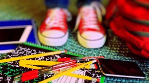 Picture of a child's shoes standing near school supplies