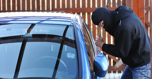 Picture of a thief breaking a car window