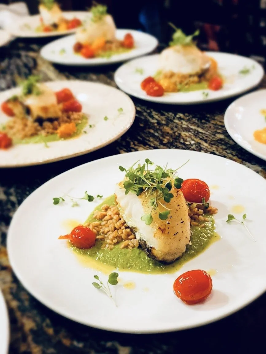 Pan seared Sea Bass with Sweet pea Puree, Toasted Faro, Blistered tomatoes, and local micro greens