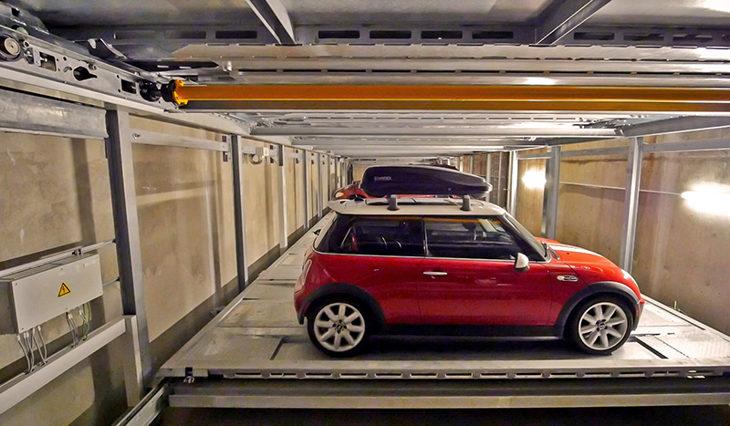 The robotic parking system stores 22 cars on two underground levels. Unlike parking structures, no special ventilation, lighting, or security is required; no elevators, stairs, or fire exits are needed to move patrons; cars are safe from damage, the…