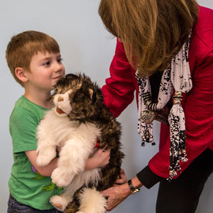 A+young+boy+and+an+instructor+hold+a+stuffed+animal+cat.jpeg