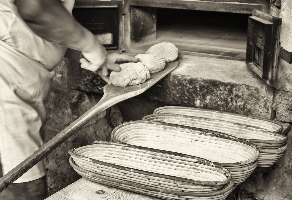 Man placing bread in a brick oven