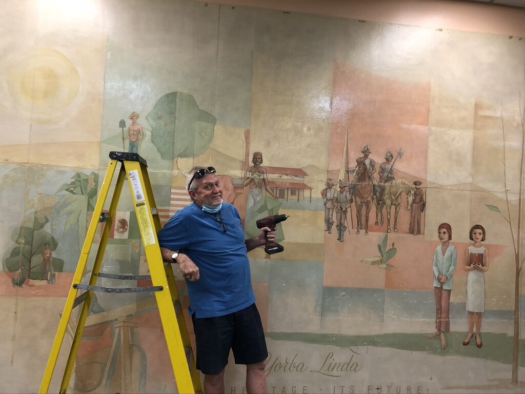 Dean Hall in front of his father's artwork.